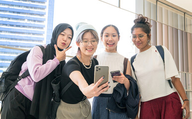 Young multi-racial women smiling and  taking group selfie together with a smartphone.