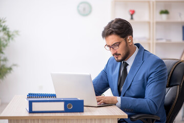 Deaf male employee using hearing aid at workplace