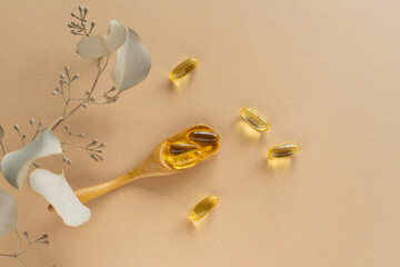 Vitamins on a white background. Capsules on spoon suitable for: fish oil, omega 3, omega 6, omega...