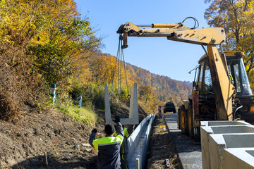 Installation of concrete drains precast in u-shapes on reconstruction road as means of draining...