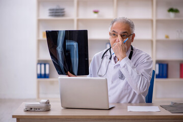 Old male doctor radiologist working in the clinic