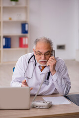 Old male doctor in telemedicine concept