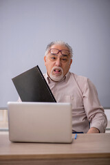 Old male teacher in front of whiteboard