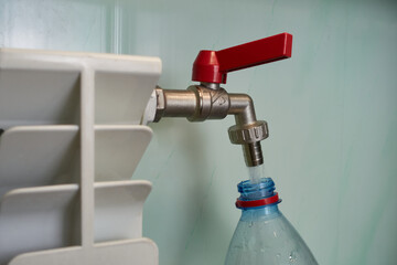 Water is taken from the radiator. From the heating element, water is drawn from the tap into a plastic bottle.