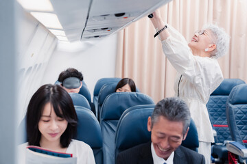 機内持ち込みの荷物を取り出す乗客