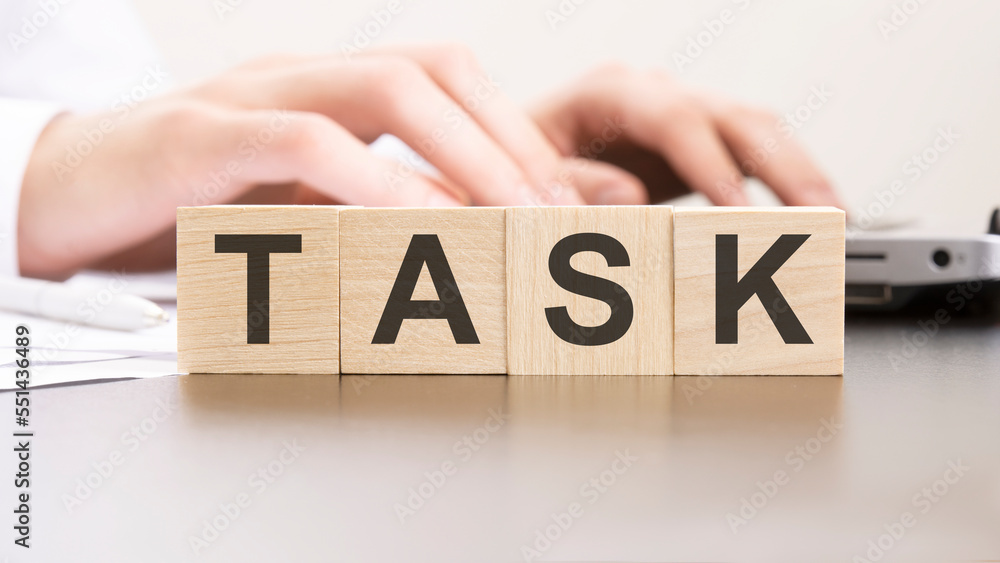Poster man made word task with wood blocks on the background of the office table. selective focus. business