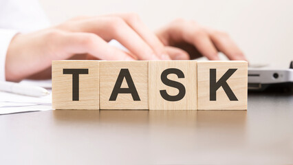 man made word task with wood blocks on the background of the office table. selective focus....