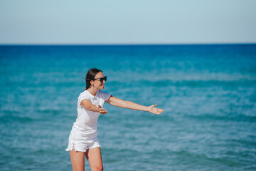 Fototapeta na wymiar Young happy woman on the beach. Girl is happy and calm in her stay on the beach