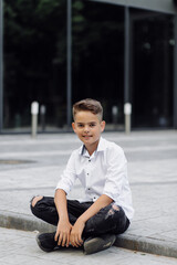 portrait of cute young fashionable boy posing outdoors