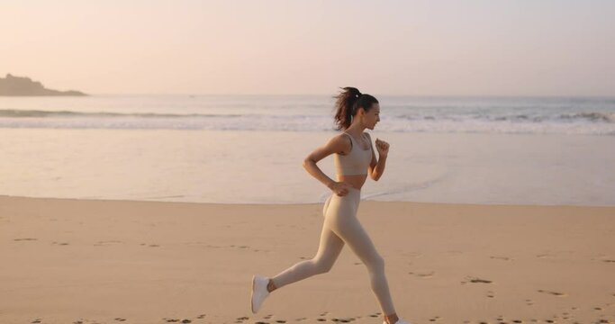 Female Runner Jogging During Outdoor Workout on the Beach in Slow