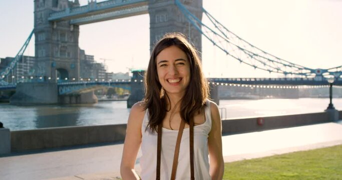 Travel, camera and photographer with woman in city of London for destination, adventure and summer. Photography, holiday and tourism with girl at river bridge for abroad trip, vacation and overseas