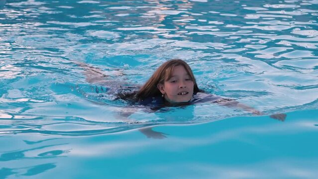 Preteen girl swimming in the pool.