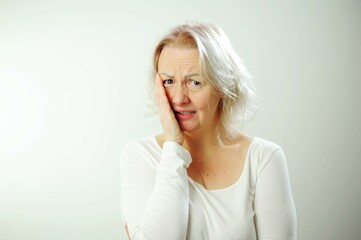 Portrait of displeased upset female frowns face as going to cry, being discontent and unhappy as can not achieve goals, isolated over white studio background. Dissapointed woman has troubles