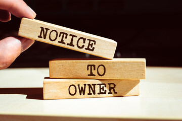 Wooden blocks with words 'Notice To Owner'.