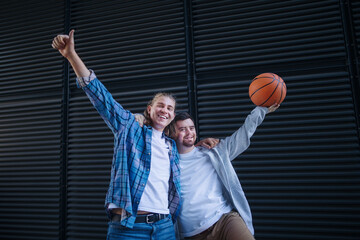 Man with down syndrome playing basketball outdoor with his friend. Concept of friendship and...