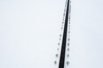 Landstra&szlig;e aus der Vogelperspektive ges&auml;umt von B&auml;umen im Winter