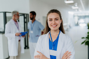 Portrait of young woman doctor at hospital corridor.