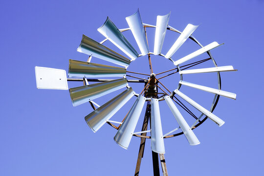 Small Rustic Windmill vintage wind turbine in blue sky