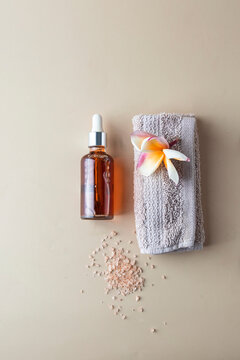 Holistic skin care concept. natural oil bottle  for massage and towel on beige background.