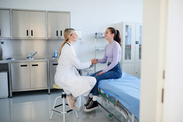 Young woman doctor examining teenage girl in her ambulance.