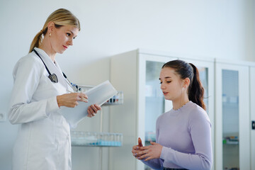 Young woman doctor examining teenage girl in her ambulance.