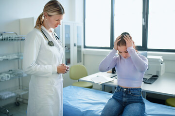 Obraz premium Young woman doctor talking with unhappy teenage girl in her ambulance.
