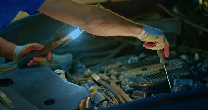 Auto mechanic working on car engine in mechanics garage. Repair service. Close-up
