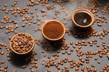 Three cups with different coffee, coffee beans, ground and ready-made drink.