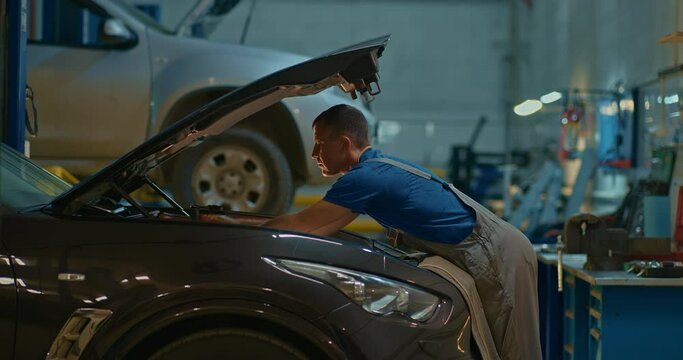 Car mechanic at a service station repairs a car. Garage. Car service.