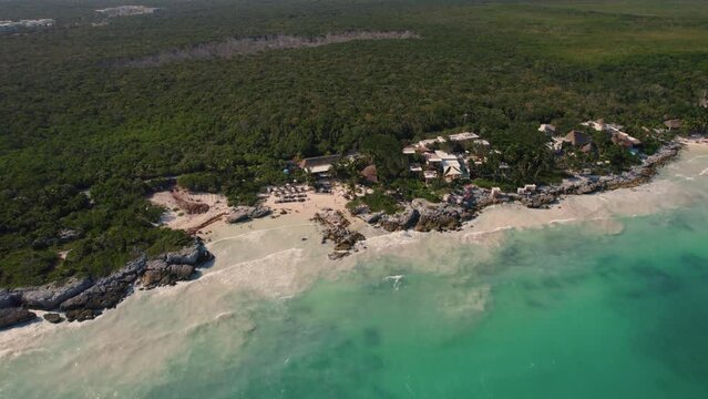 Aerial descending shot of luxury Gitano Beach Cub with scenic landscape in background - Tulum,Mexico