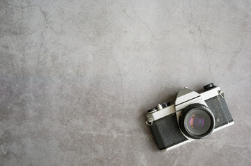 Vintage old camera on cement floor background. Film camera retro style 1970s. Top view with copy...
