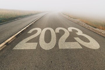 2023 new year uncertainty, number on asphalt road to infinity disappearing in foggy diminishing perspective