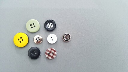Various kinds of clothes buttons on grey background