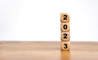 Wooden Cube turns from 2022 to 2023 on wooden table,Happy new 2023 year, countdown and New Year holiday concepts.