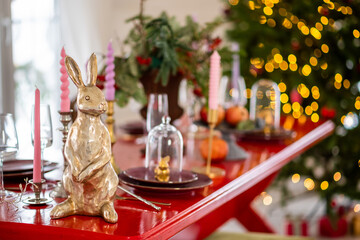 symbol of the year is a golden hare on a red table. Christmas lights garlands