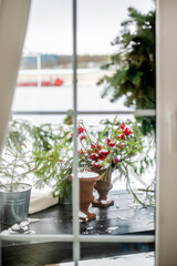 View from a large window on a snow-covered street. Table with winter Christmas decorations