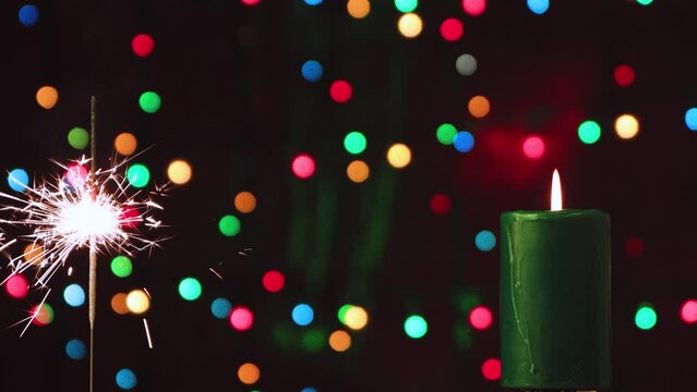 Burning candle and sparkler against the background of colored lights. Congratulation, postcard. Background, insert captions, inscription, congratulations. Video, footage, intro, copy space. UHD 4K.
