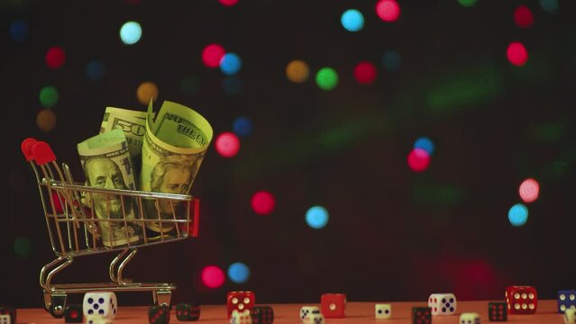 A cart with dollars in front of a flashing colored Christmas garland. Congratulation, postcard. Background, insert captions, congratulations. Video, footage, intro, copy space. UHD 4K.
