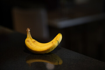 two ripe banana on a black background with a reflection.
