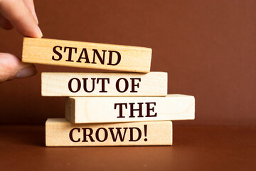 Wooden blocks with words 'Stand out of the crowd'.