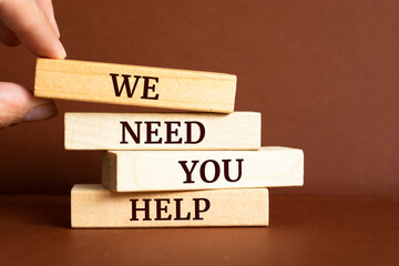 Wooden blocks with words 'We need you HELP'.