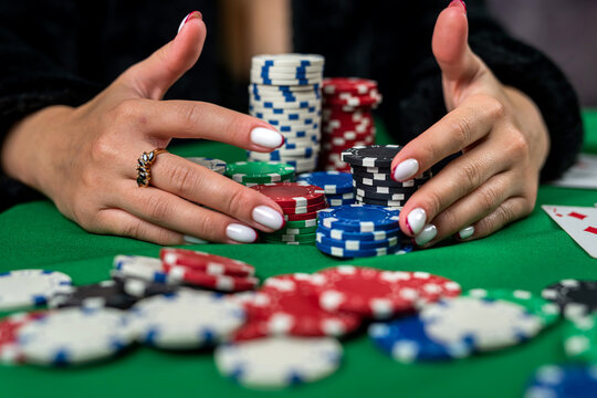 woman in dress wins a game of blackjack and is happy with all the chips after playing poker.