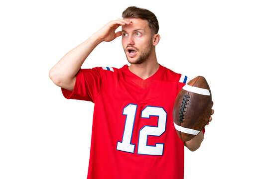 Young caucasian man playing rugby over isolated chroma key background doing surprise gesture while looking to the side - Powered by Adobe