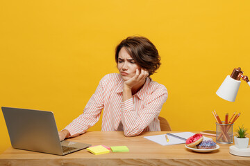 Young tired sad weary employee IT business woman wear casual shirt sit work at office desk using...