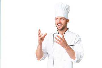 Young caucasian chef over isolated chroma key background with surprise facial expression