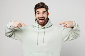 Young exultant overjoyed jubilant unshaven caucasian man wear mint hoody look camera point index finger on himself isolated on plain solid white background studio portrait. People lifestyle concept.