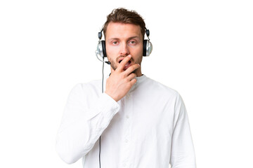 Telemarketer caucasian man working with a headset over isolated chroma key background surprised and shocked while looking right