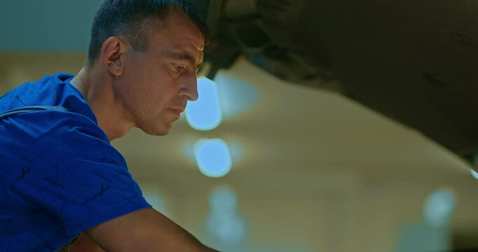 Automotive mechanic man open a car hood and check up the engine. Worker work in mechanics garage, check and maintenance to repair the motor car car in workshop.