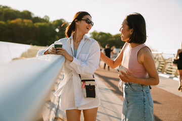 Young beautiful smiling asian girl talking to her friend