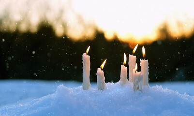Christmas candles on snow close up, magic winter evening scene. beautiful winter natural background with candles. Christmas, Yule sabbat, New Year Holidays concept. witchcraft ritua - obrazy, fototapety, plakaty